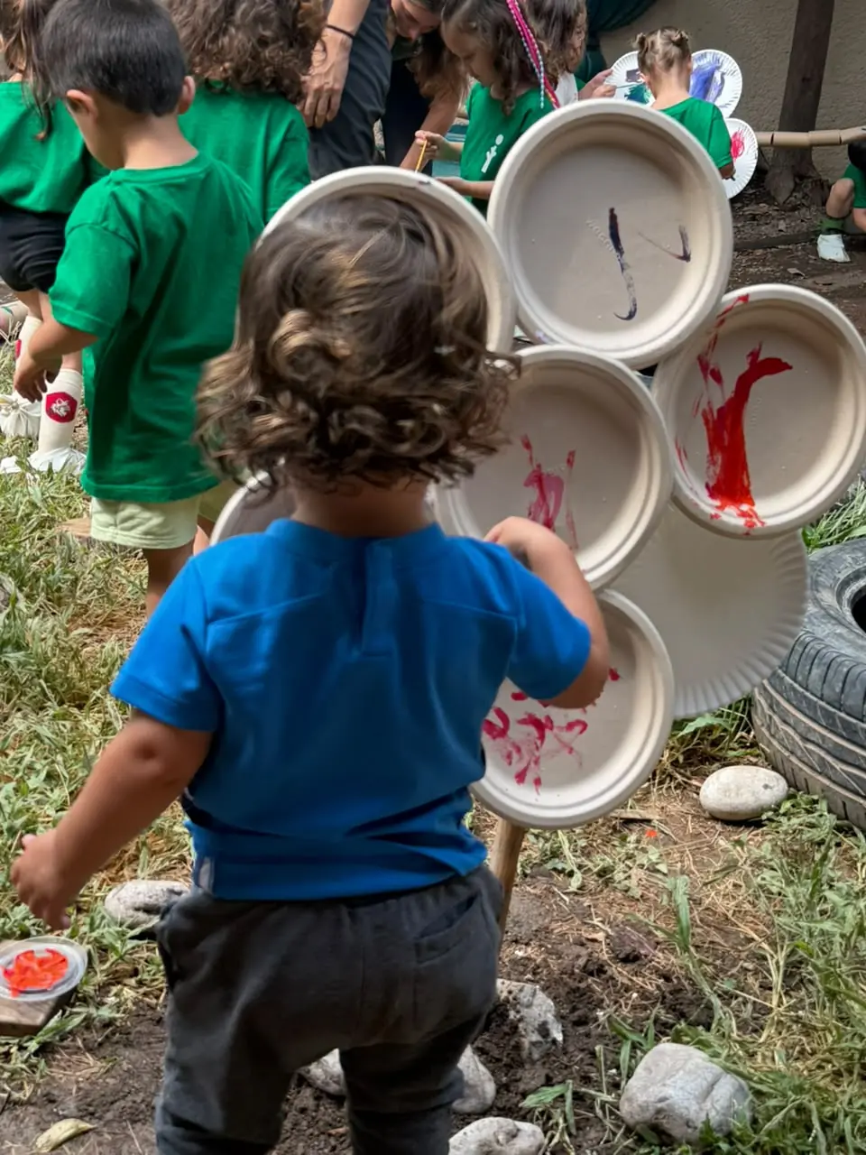 Niñas y niños pintando y creando al aire libre