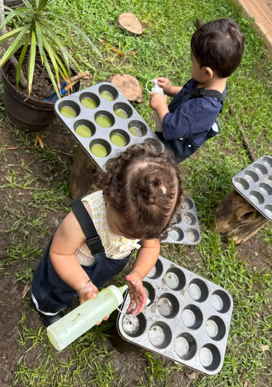 Niñas y niños experimentando con agua en el jardín