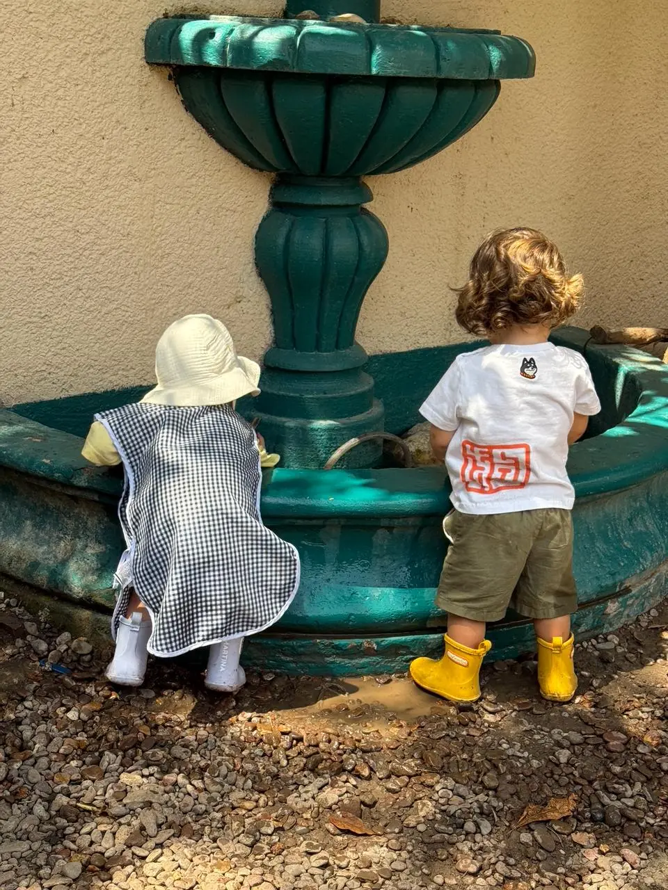 Dos niños explorando una fuente en el jardín de Tiny Garden Kinder